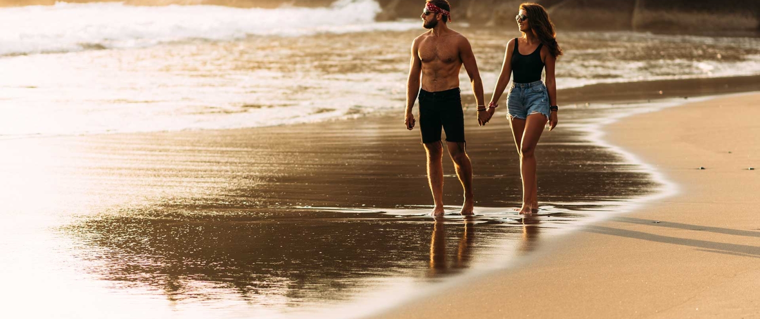 a-happy-couple-walks-along-a-sandy-beach-on-the-is-2021-11-02-21-28-17-utc